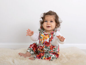 toddler sitting on sheepskin rug